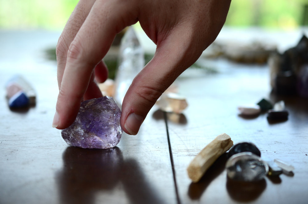 Hand grabbing healing crystal